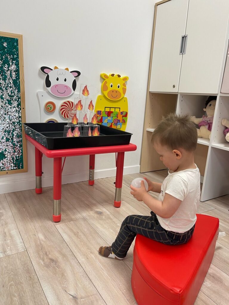 Dziecko trzyma w dłoni piłkę. 